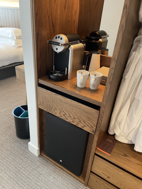a coffee machine and coffee mugs on a shelf