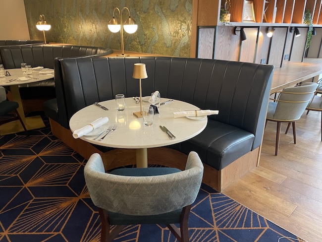 a table with a lamp and a table set in a restaurant