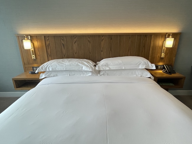a bed with white sheets and pillows