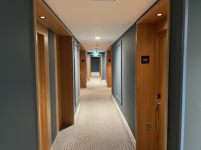 a hallway with doors and a carpeted floor