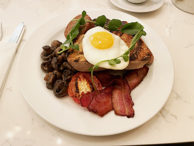 a plate of food with a egg on top