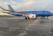a blue airplane on a runway