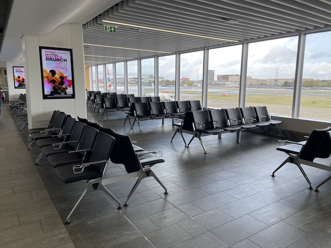 a row of chairs in a room with large windows