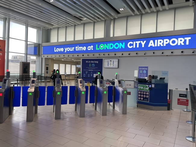 a gated entryway with blue and green signs