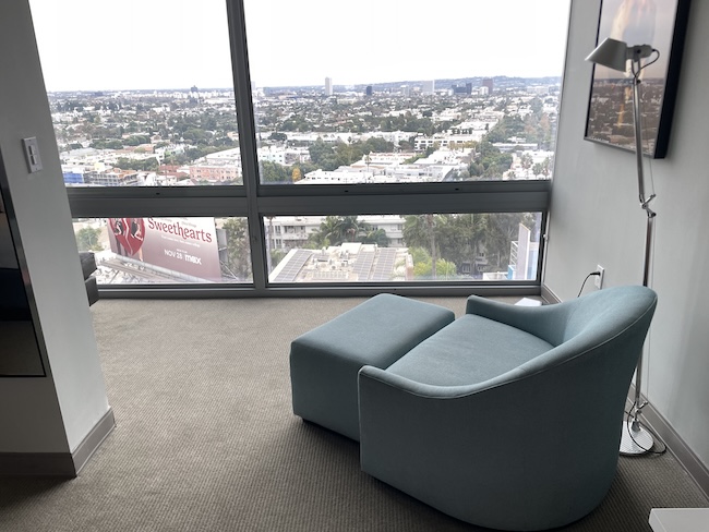 a chair in a room with a view of a city