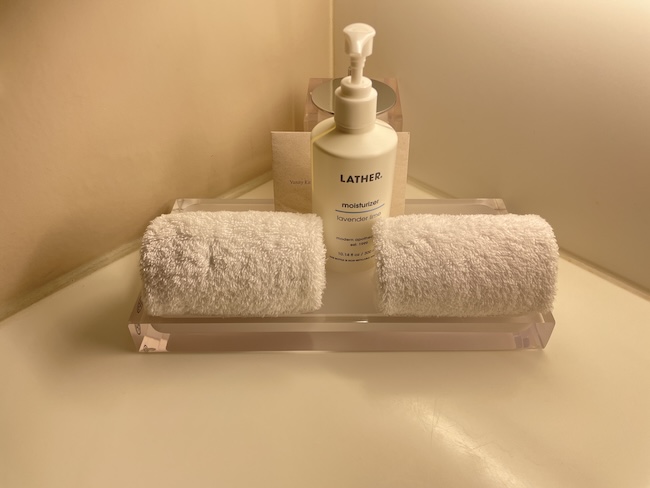 a white bottle and two towels on a glass tray