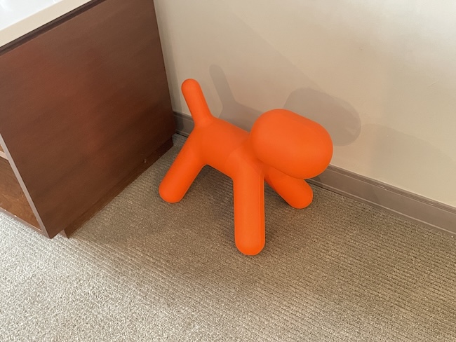 an orange balloon dog on carpet