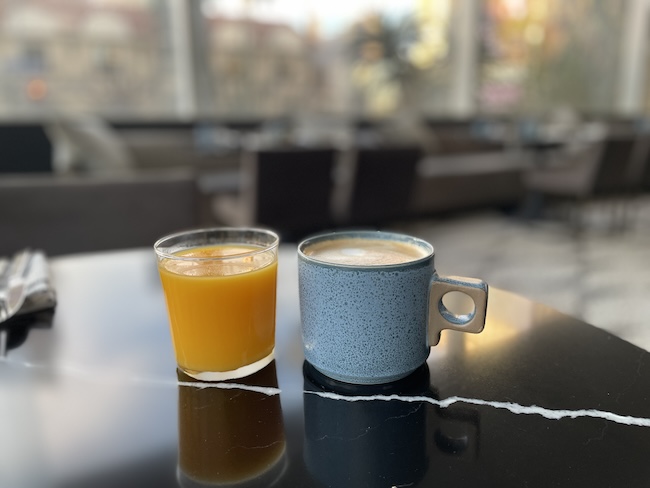 two cups of coffee and orange juice on a table