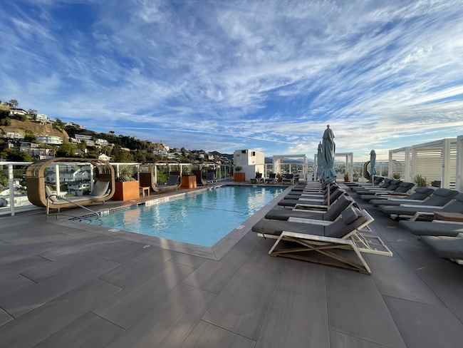 a pool with lounge chairs and a building in the background