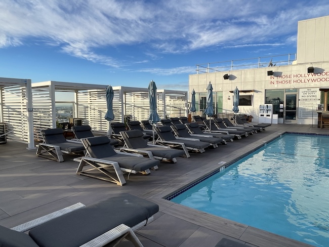 a pool with lounge chairs and umbrellas