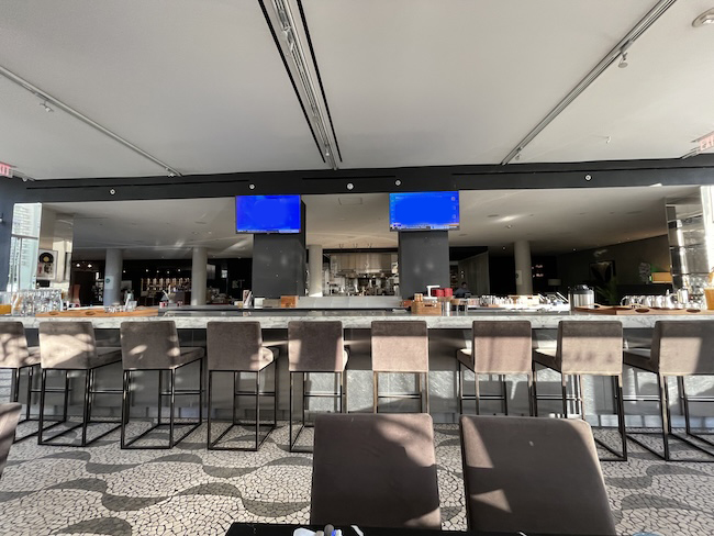 a bar with chairs and a tv