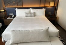 a bed with a white sheet and a pillow