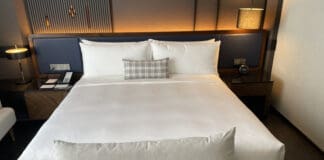 a bed with a white sheet and a pillow