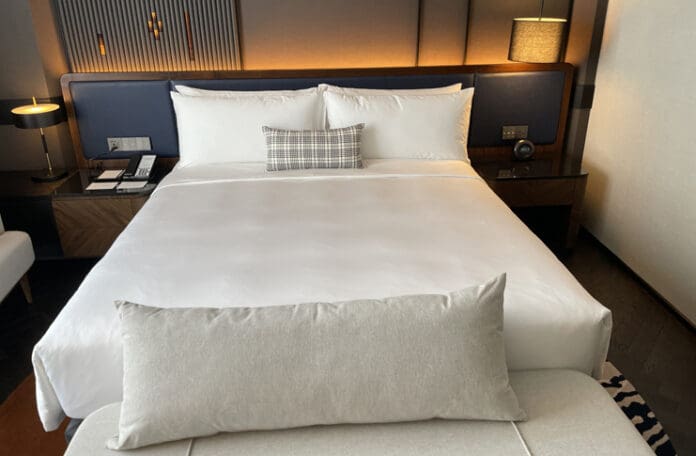 a bed with a white sheet and a pillow