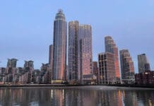 a city skyline with many tall buildings and a body of water