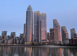 a city skyline with many tall buildings and a body of water