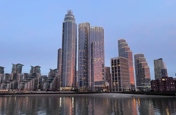 a city skyline with many tall buildings and a body of water
