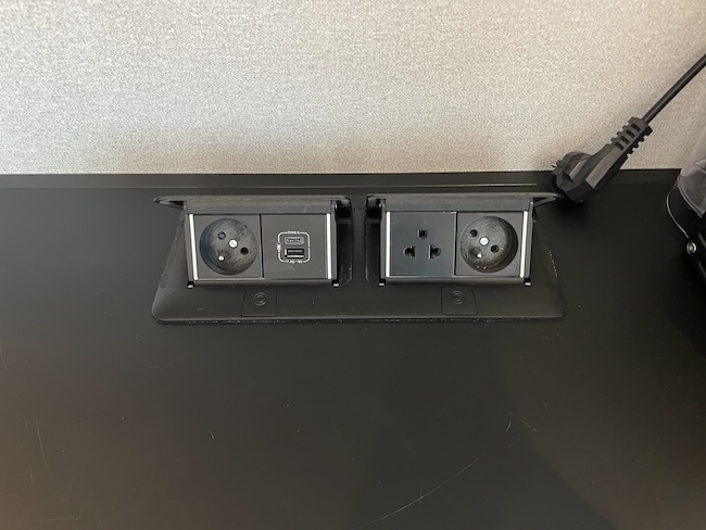 a black rectangular outlet with plugs and sockets