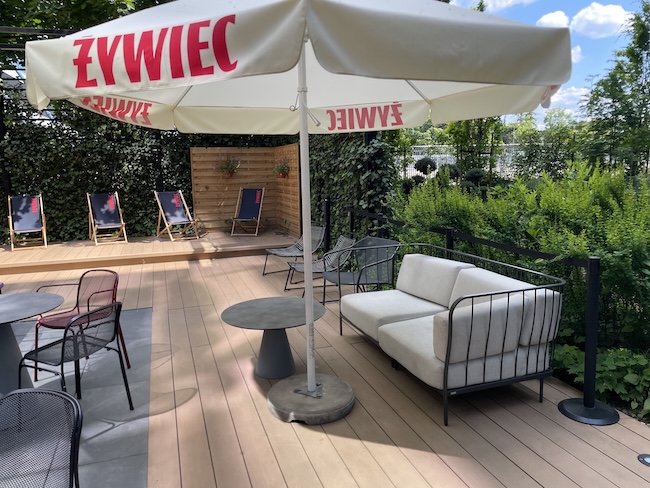 a patio with a white couch and umbrella