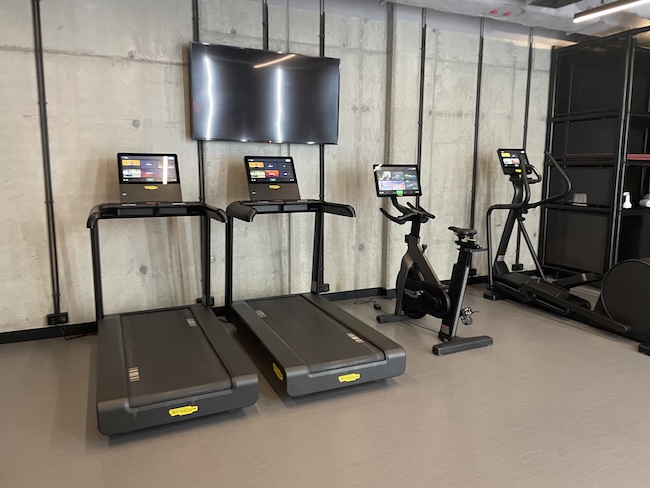 a group of treadmills and laptops in a room