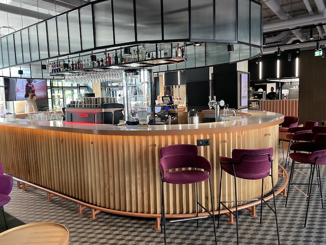 a bar with chairs and a bar