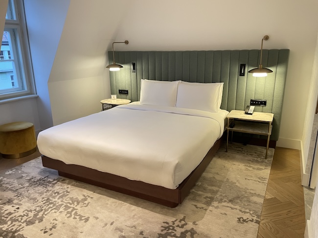 a bed with a green headboard and lamps