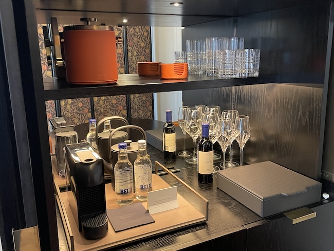 a shelf with wine glasses and bottles