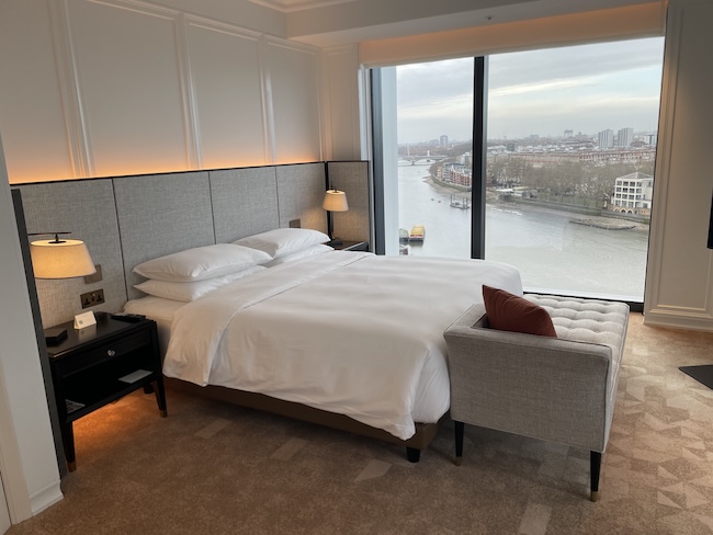 a bedroom with a large window overlooking a river
