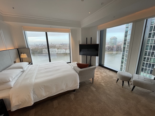a bedroom with a large window overlooking a city