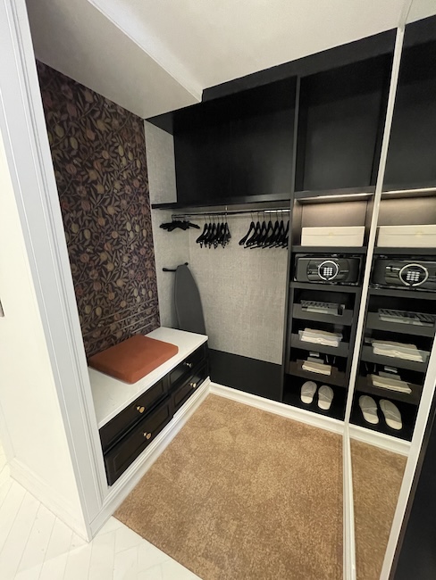 a closet with black shelves and white walls