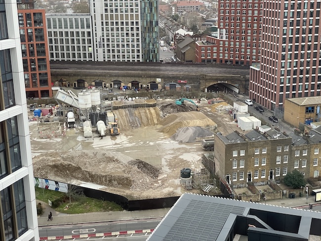 a construction site with many buildings and a bridge