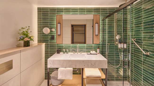 a bathroom with a sink and green tile wall