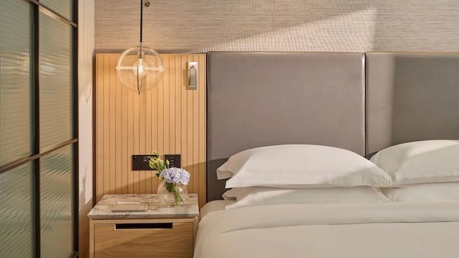 a bed with a light fixture and a table