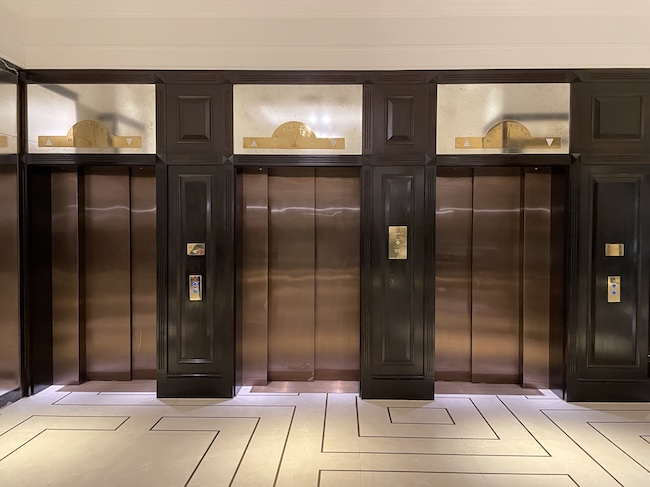 a row of elevators with glass doors