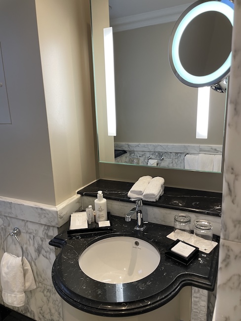 a bathroom sink with a round mirror