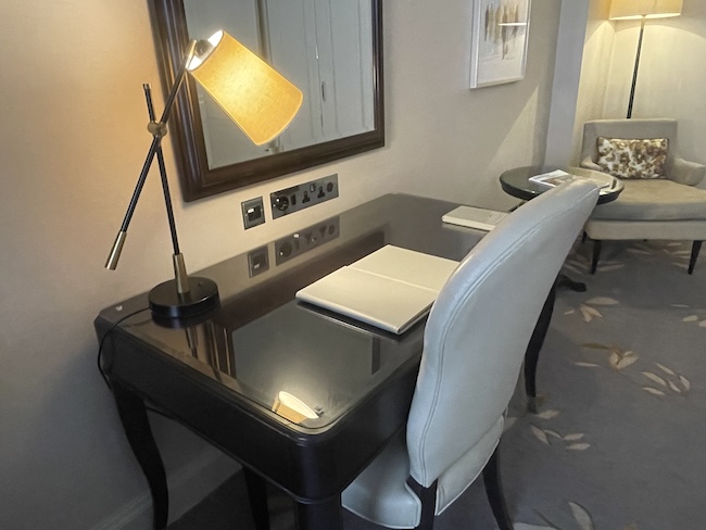 a desk with a lamp and a mirror