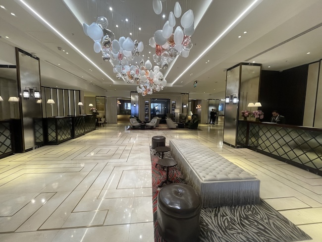 a lobby with a long bench and balloons from the ceiling