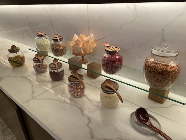 a shelf with glass jars of food and spoons