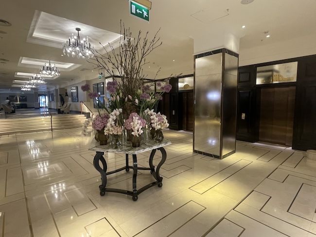a large vase of flowers on a table in a lobby