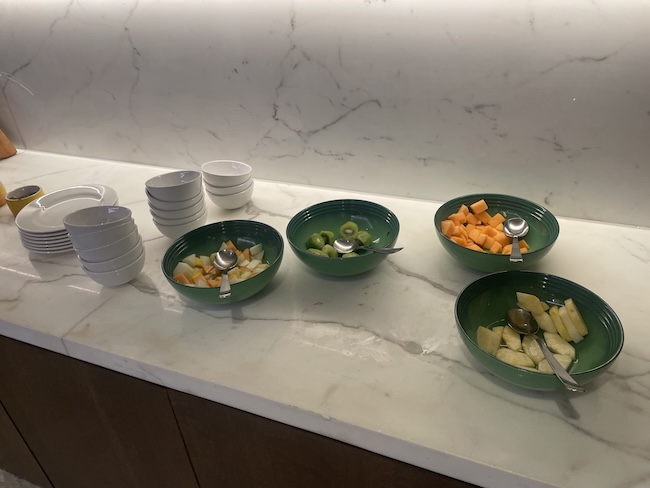 a group of bowls of fruit and a spoon on a counter
