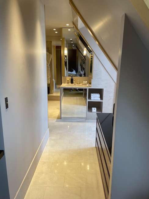 a hallway with a mirror and a sink