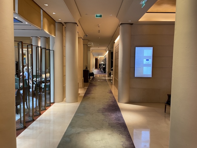 a hallway with columns and a sign