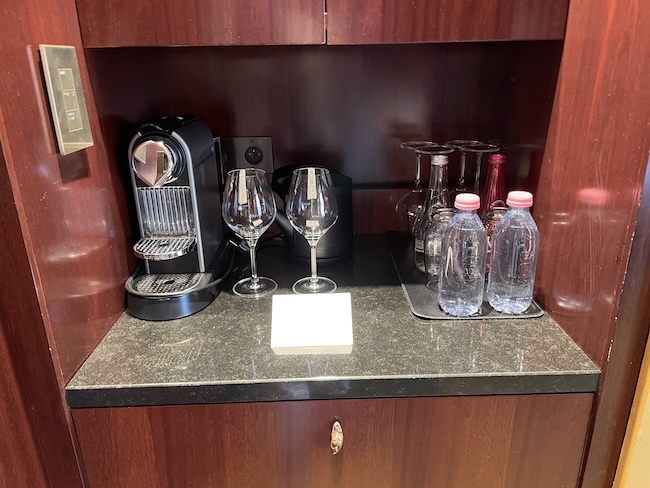 a coffee machine and wine glasses on a counter
