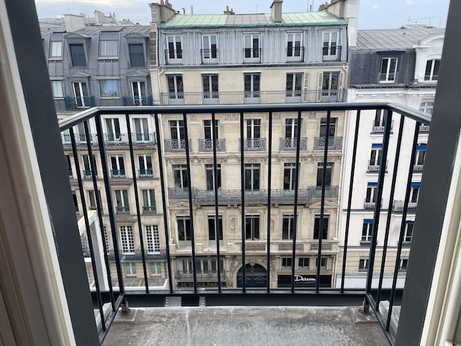 a balcony with a railing and a view of a city