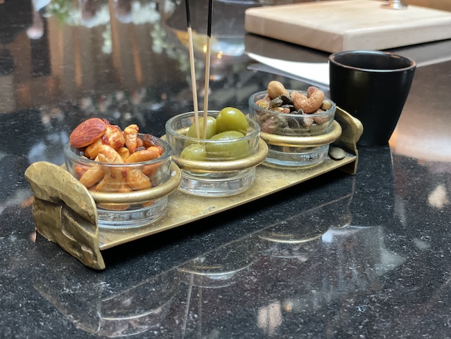 a group of bowls of nuts and olives on a table