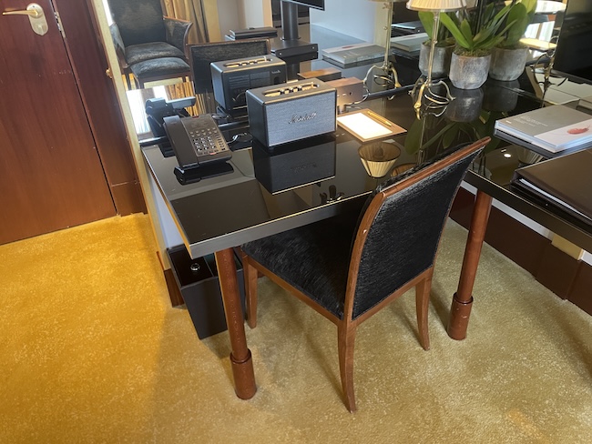 a desk with a speaker and a chair