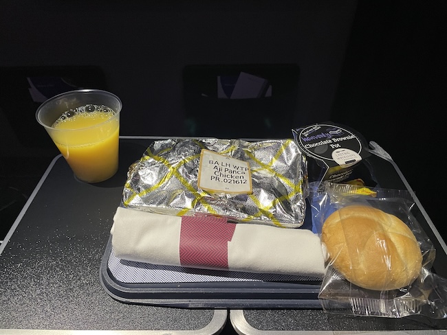 food on a tray with a drink and a sandwich