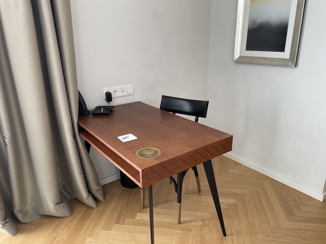 a desk with chair and a picture on the wall