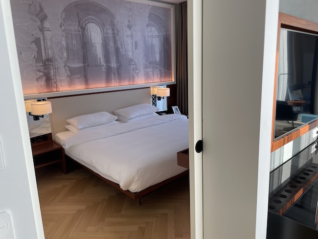 a bed with white sheets and lamps in a room