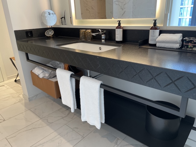 a bathroom with a black countertop and white towels